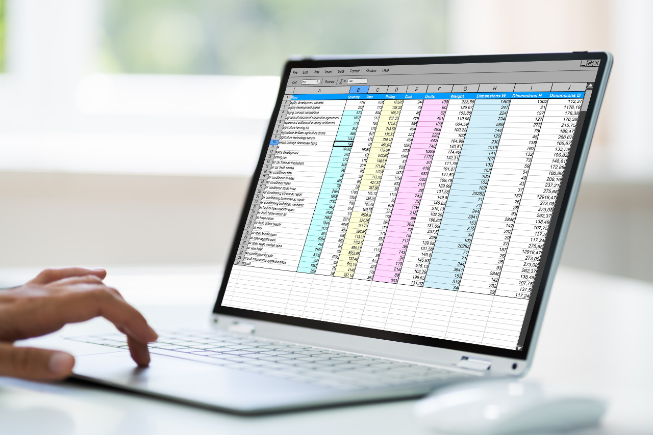 Female employee works on spreadsheet from laptop.