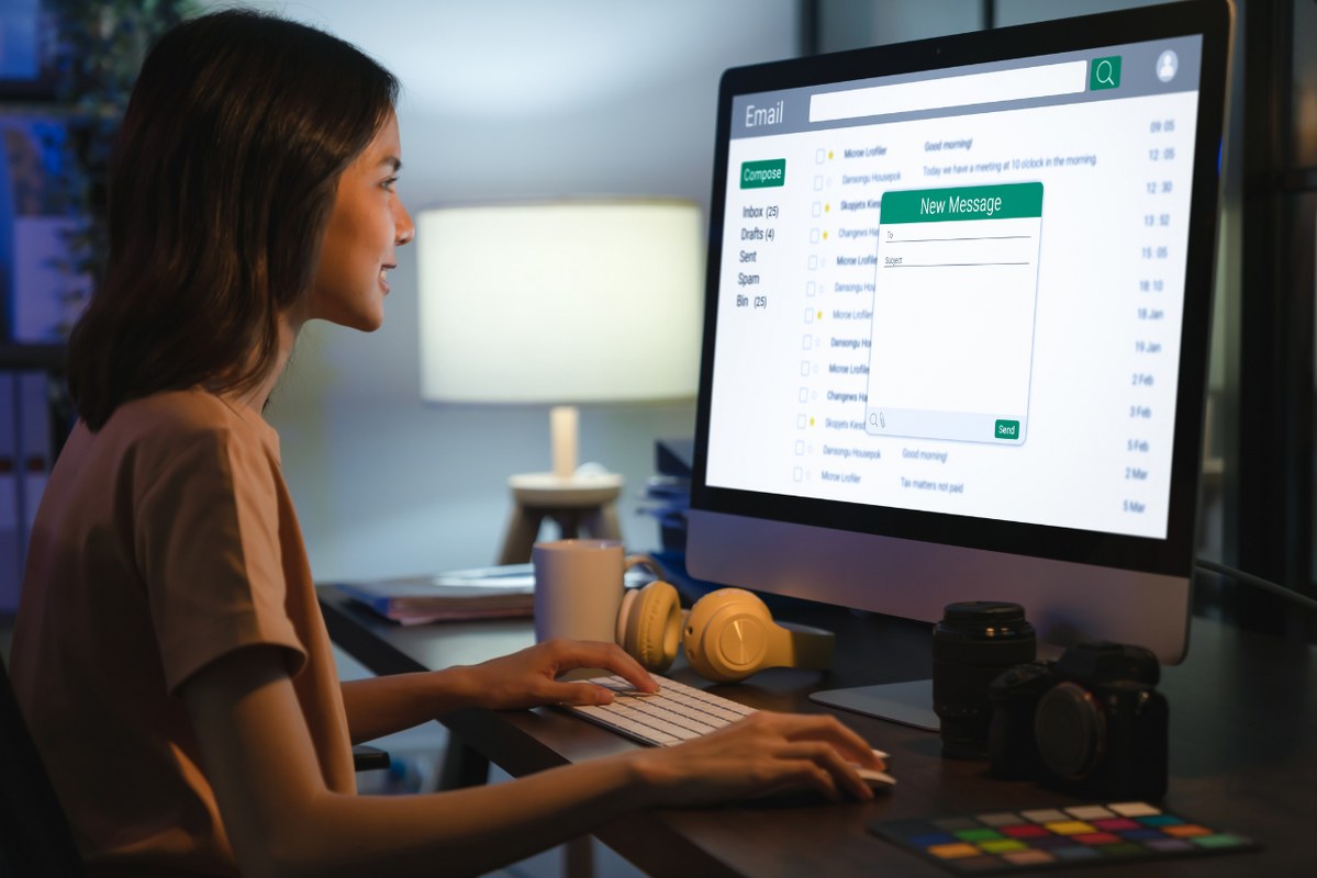 Female entrepreneur composes email to kickstart email marketing.