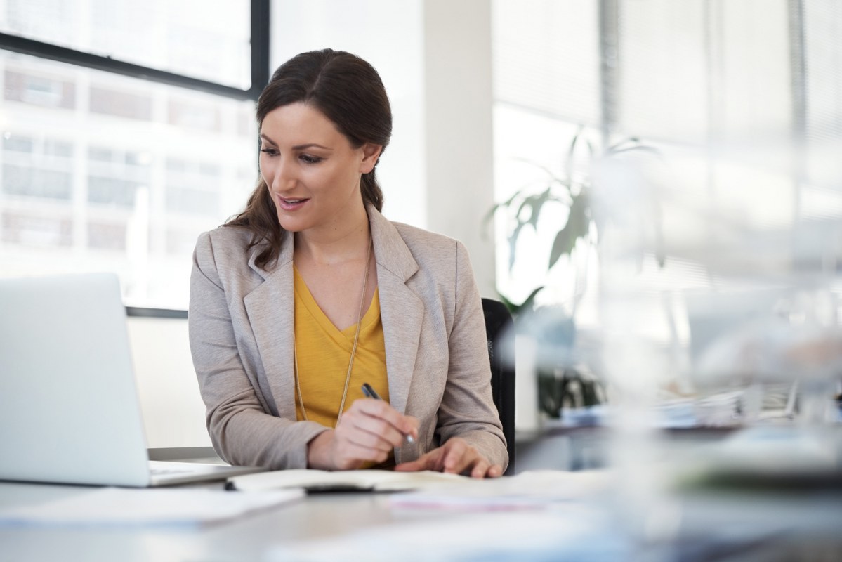 Female entrepreneur focuses on laptop to learn from competitors.