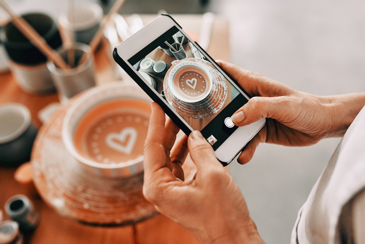 Female entrepreneur takes a photo of pretty mug to post on social media.
