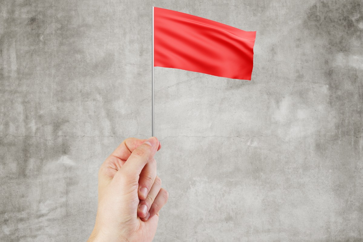 Hand holding red flag.