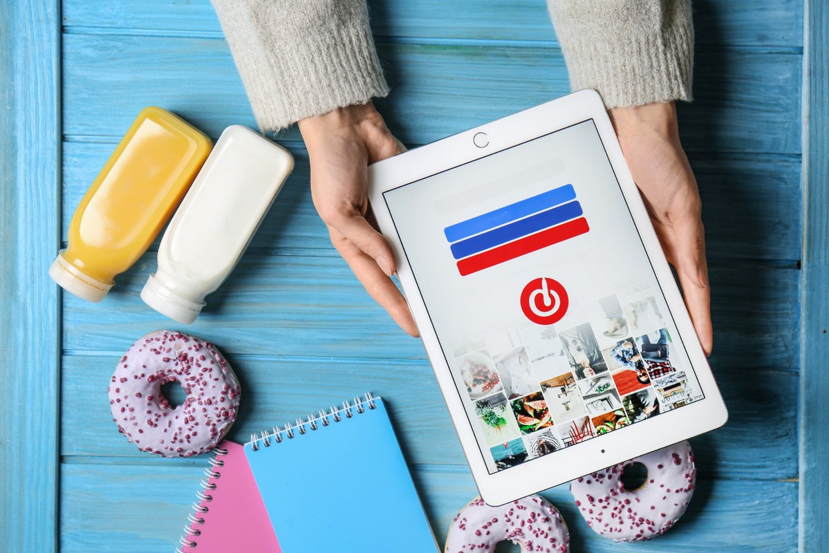 Inverted view of woman Holding IPad with Pinterest Login Page on Screen.