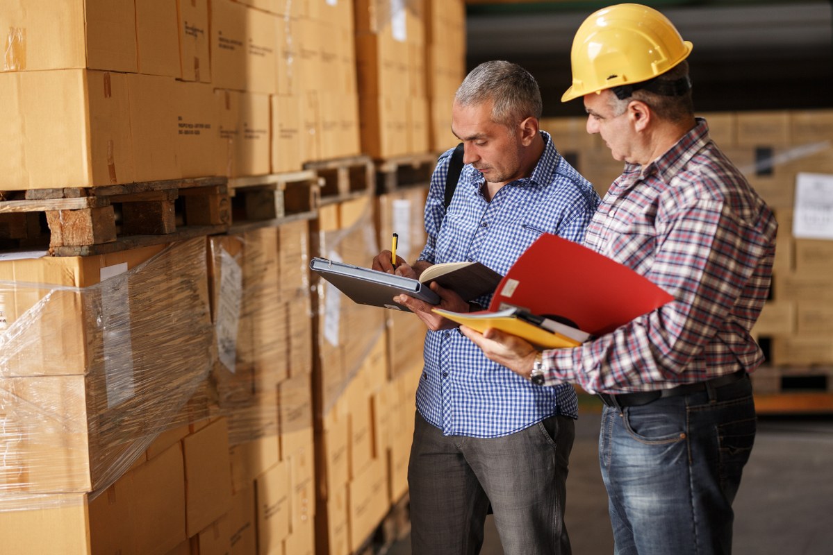 Male customs worker signing shipping clearance.