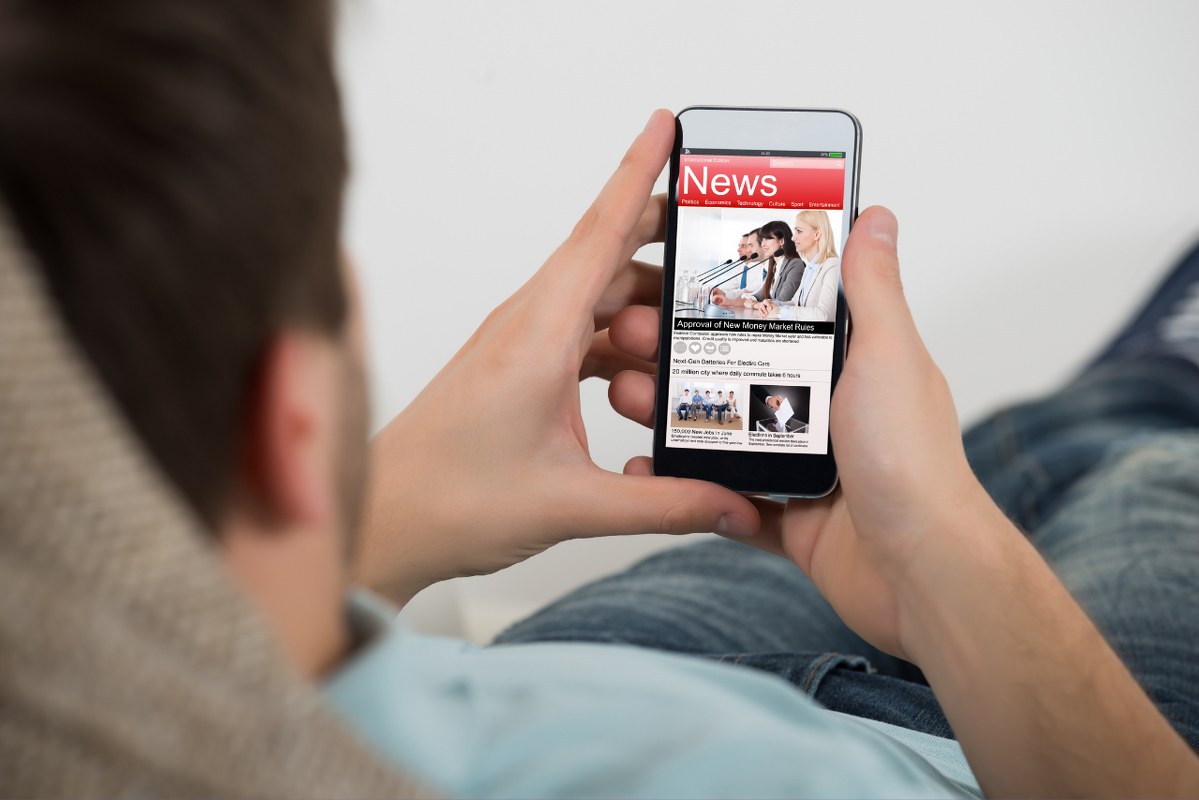 Man Reading Online local News On Mobile Phone.