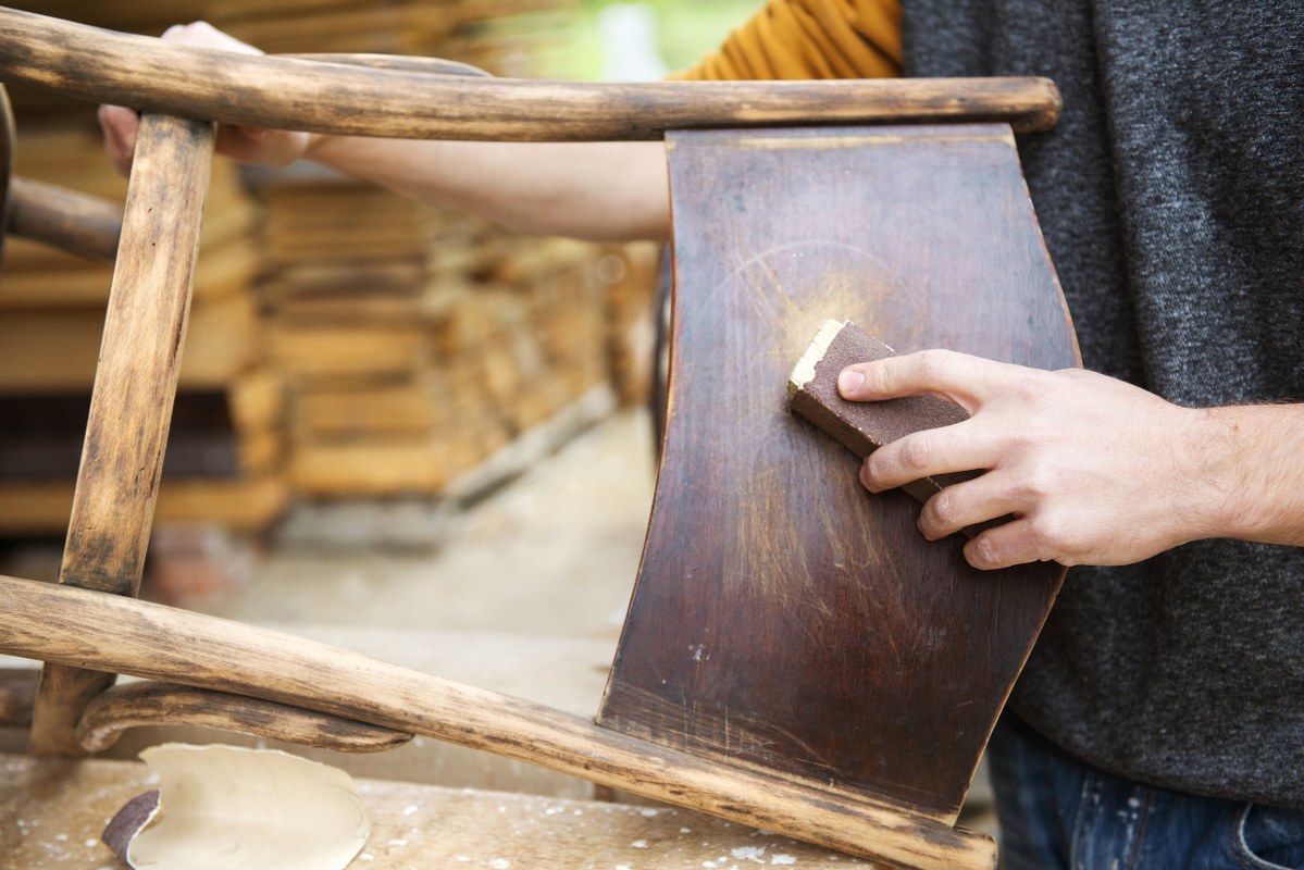 Man restores wooden furniture.