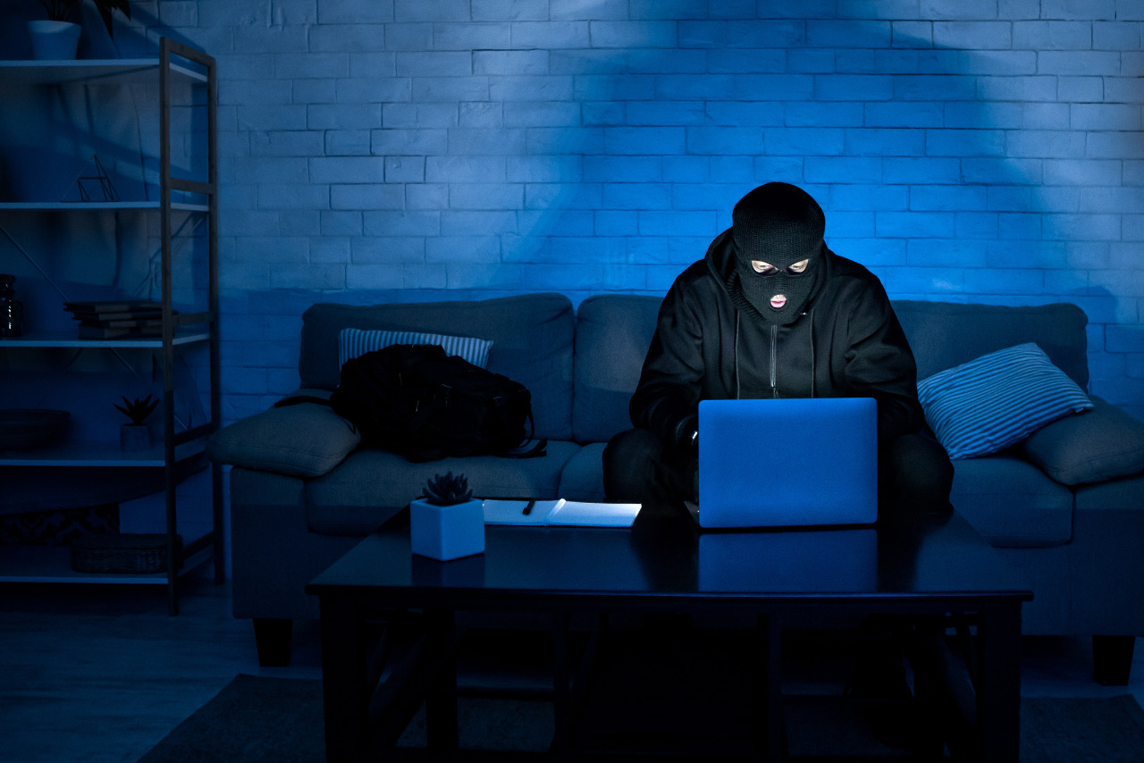 Online theft in Mask Working in a dark liiving room.