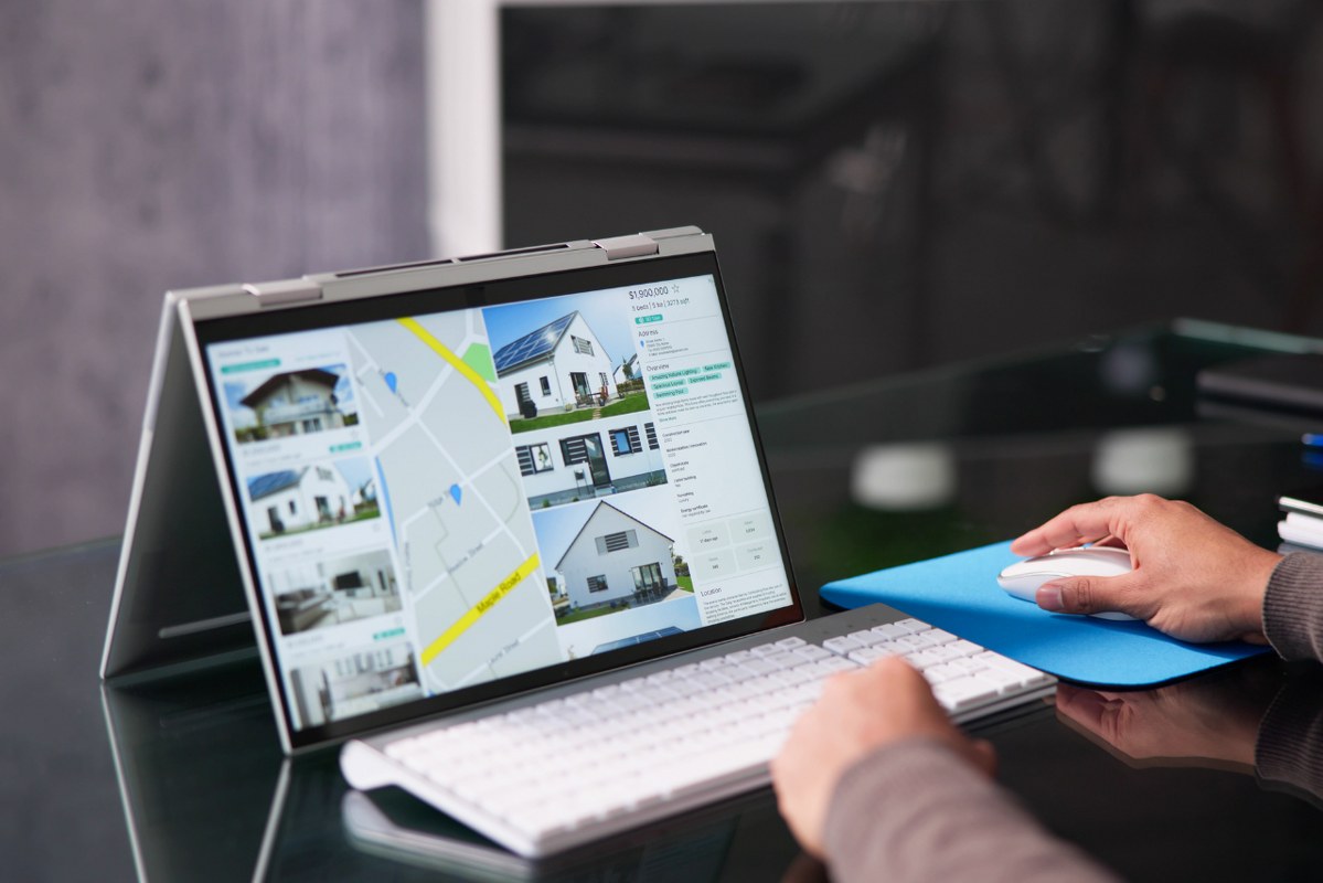 Person accessing property listings on real estate website using tablet.