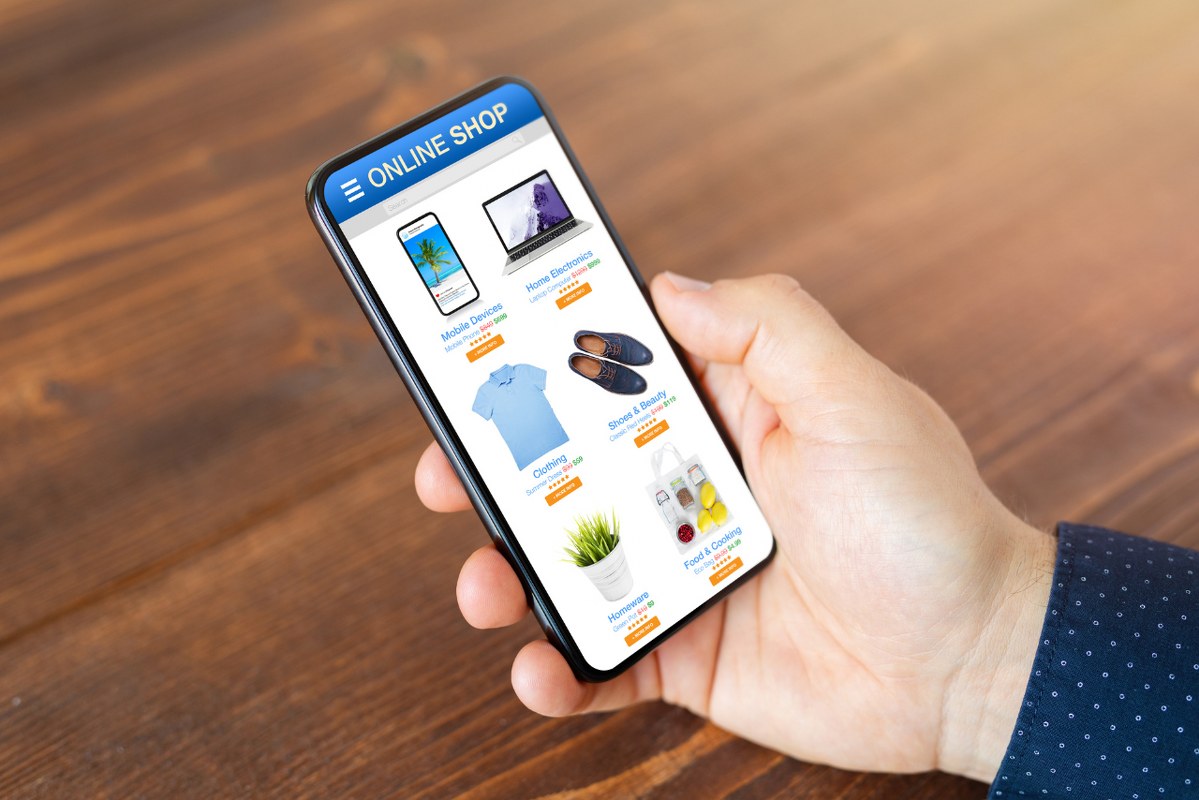 Person's hand using smartphone while accessing online shop.