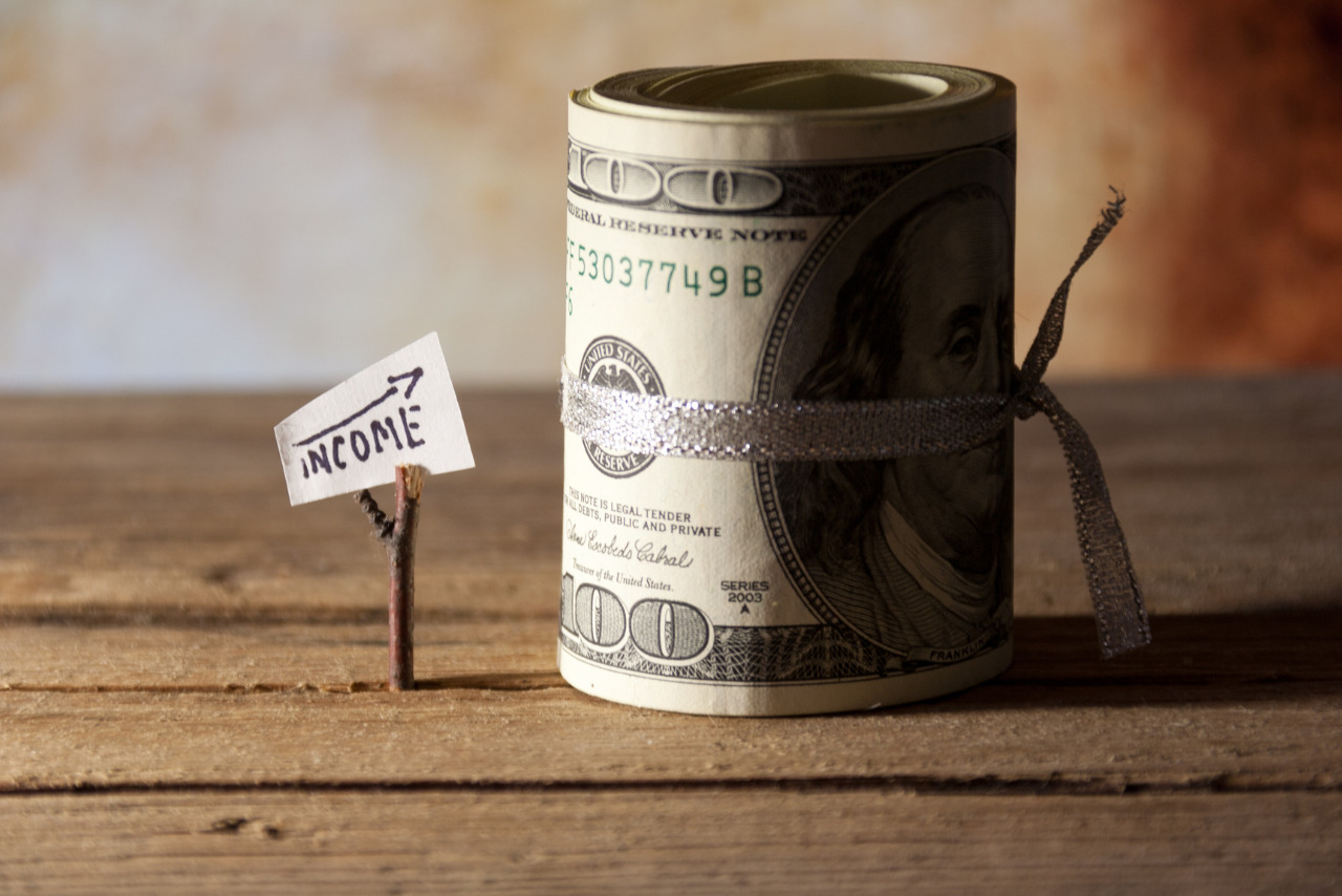 Rolled-up cash placed next to a sheet of paper featuring an upward arrow and the word 