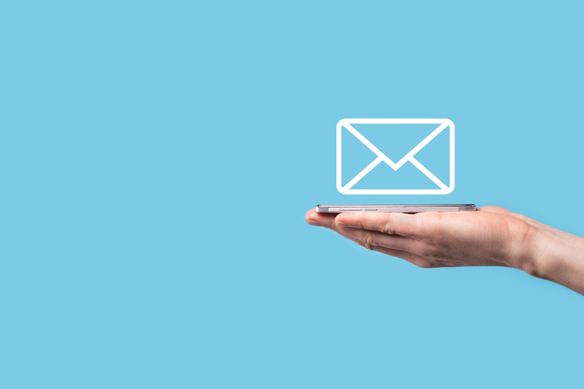 Single hand holding smartphone with envelope icon afloat.