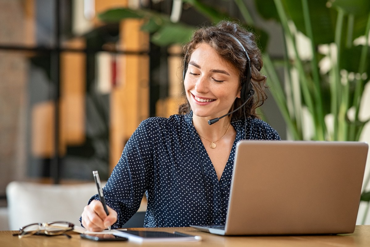 Successful customer service representative using laptop at office.