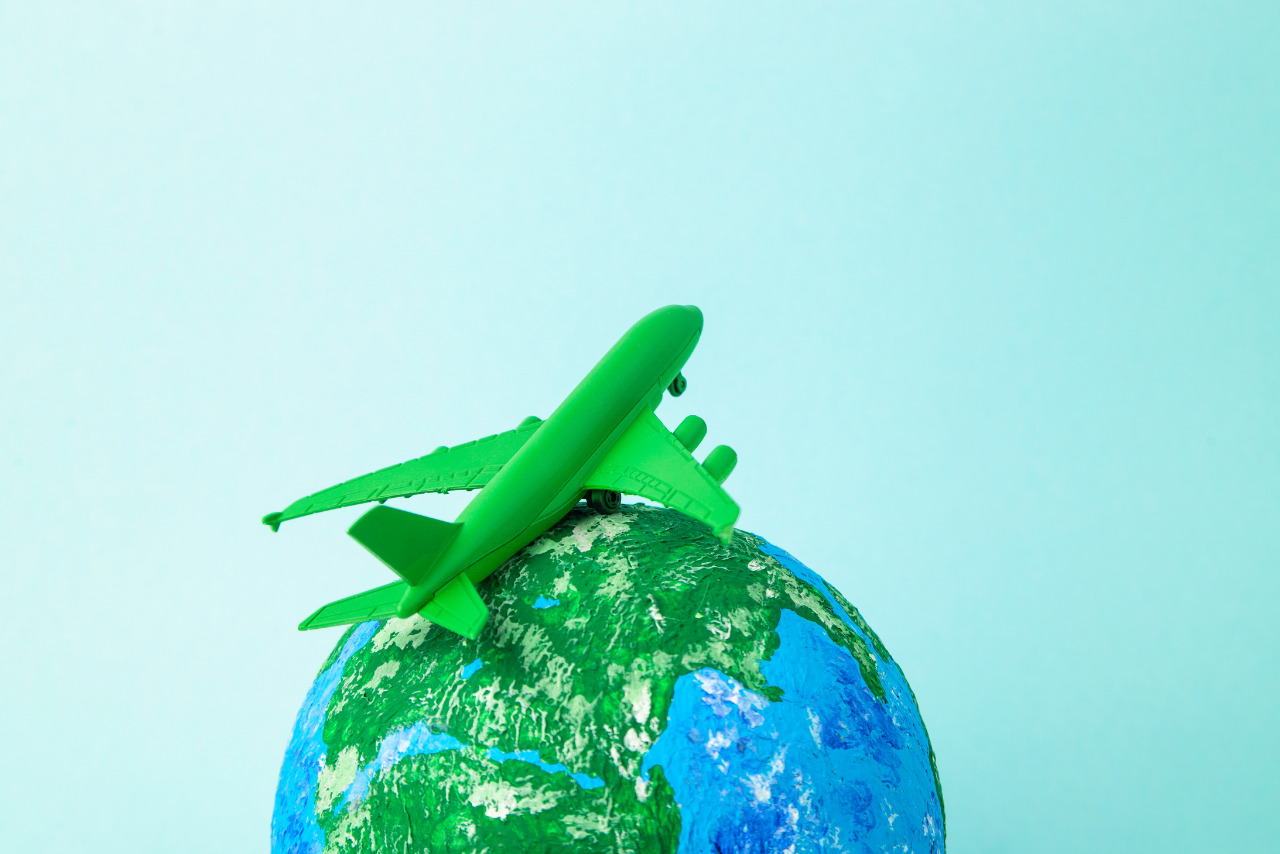 Sustainable eco friendly flight concept: green airplane on top of globe. 