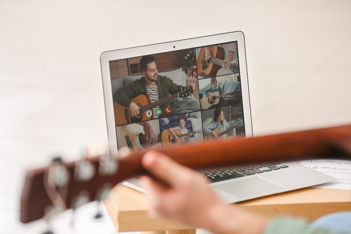 Teacher Giving Music Lessons Online to people from different countries at Home.