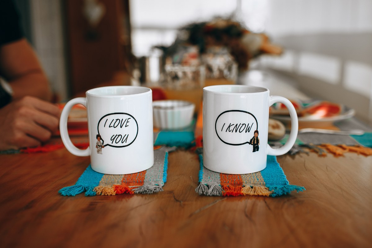 Two White Ceramic Mugs on table.