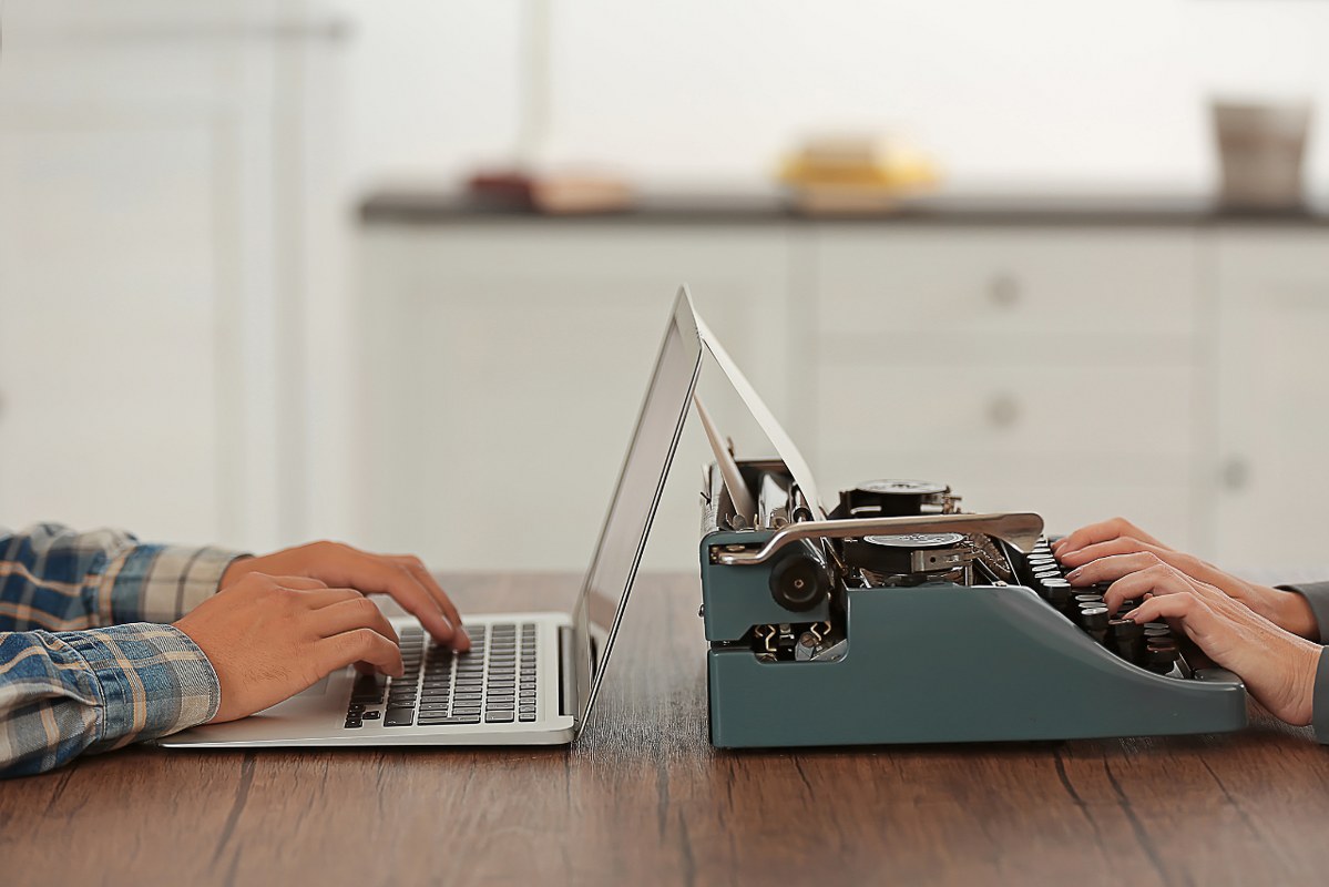 Typewriter and Laptop on a Wooden Table.