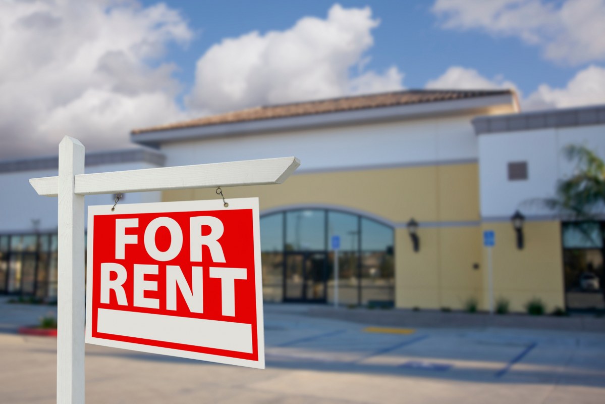 Vacant Retail Building with for Rent Real Estate Sign.