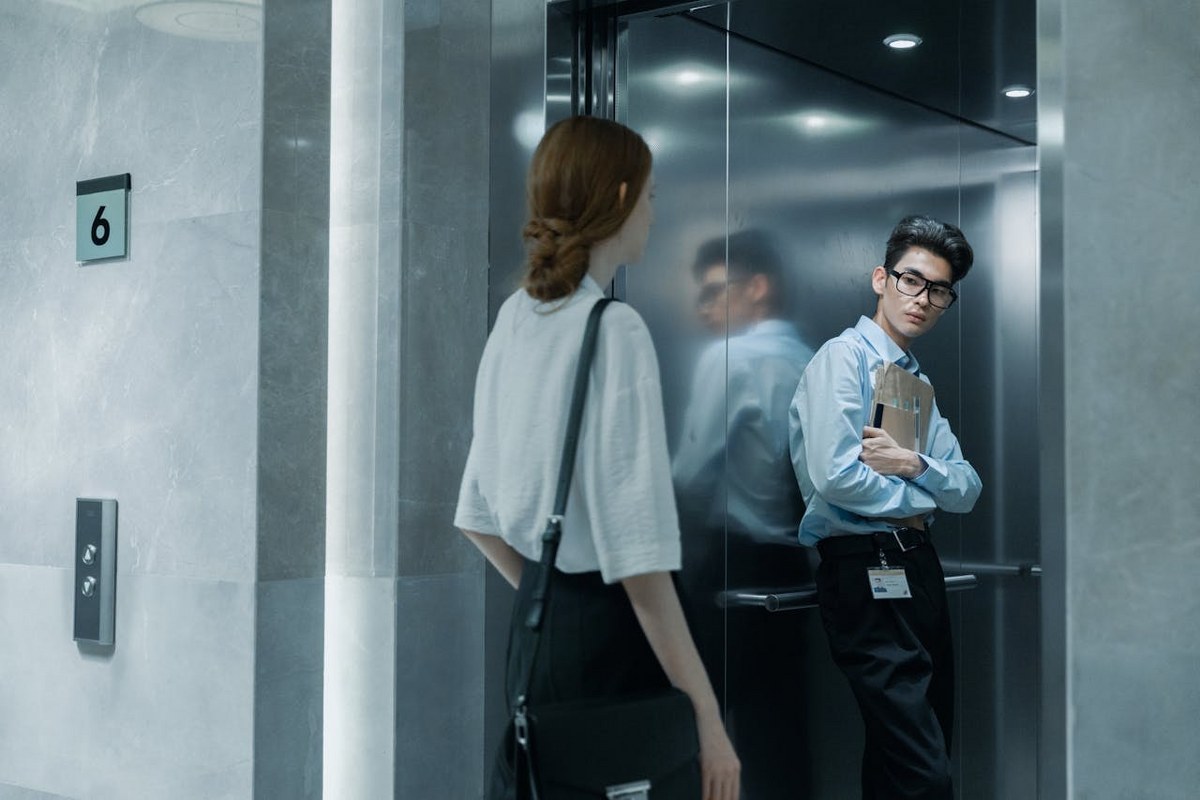 A business woman and a man in an elevator.
