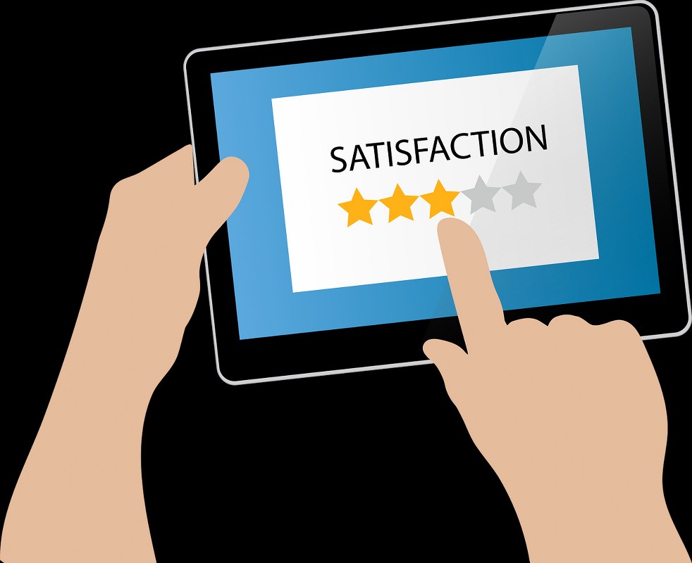 A figure of a hand selecting the level of satisfaction on a tablet.