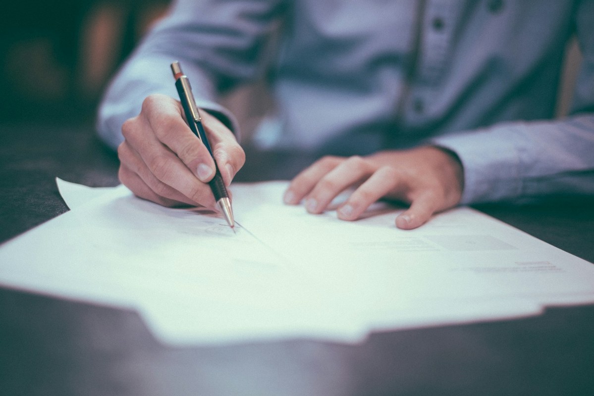 A man is signing contract.