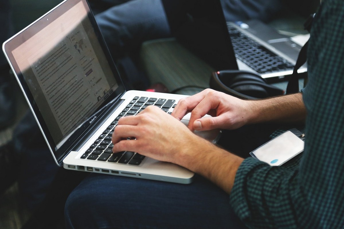 A man using a laptop to open a digital document.