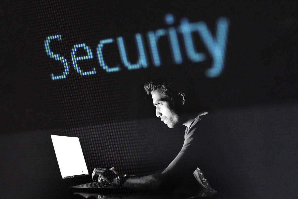 A man working on a computer with a dark background.