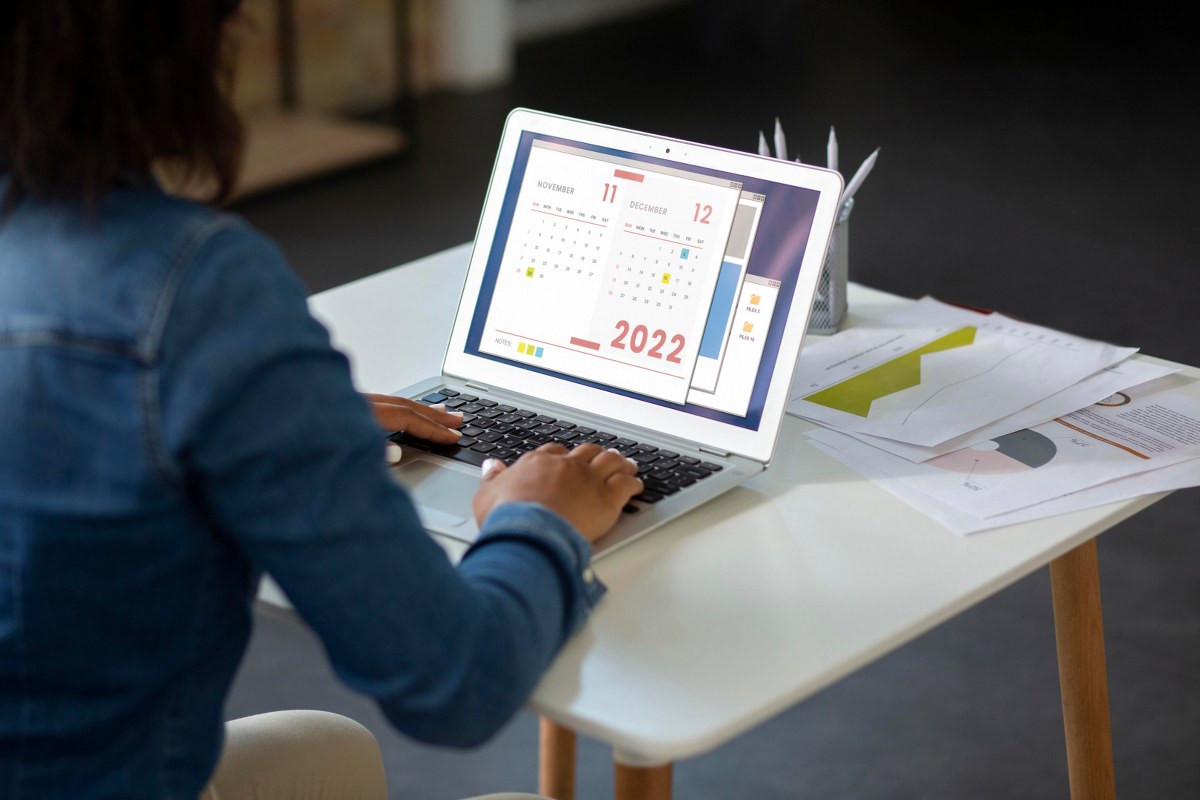 A person making a calendar on a laptop.