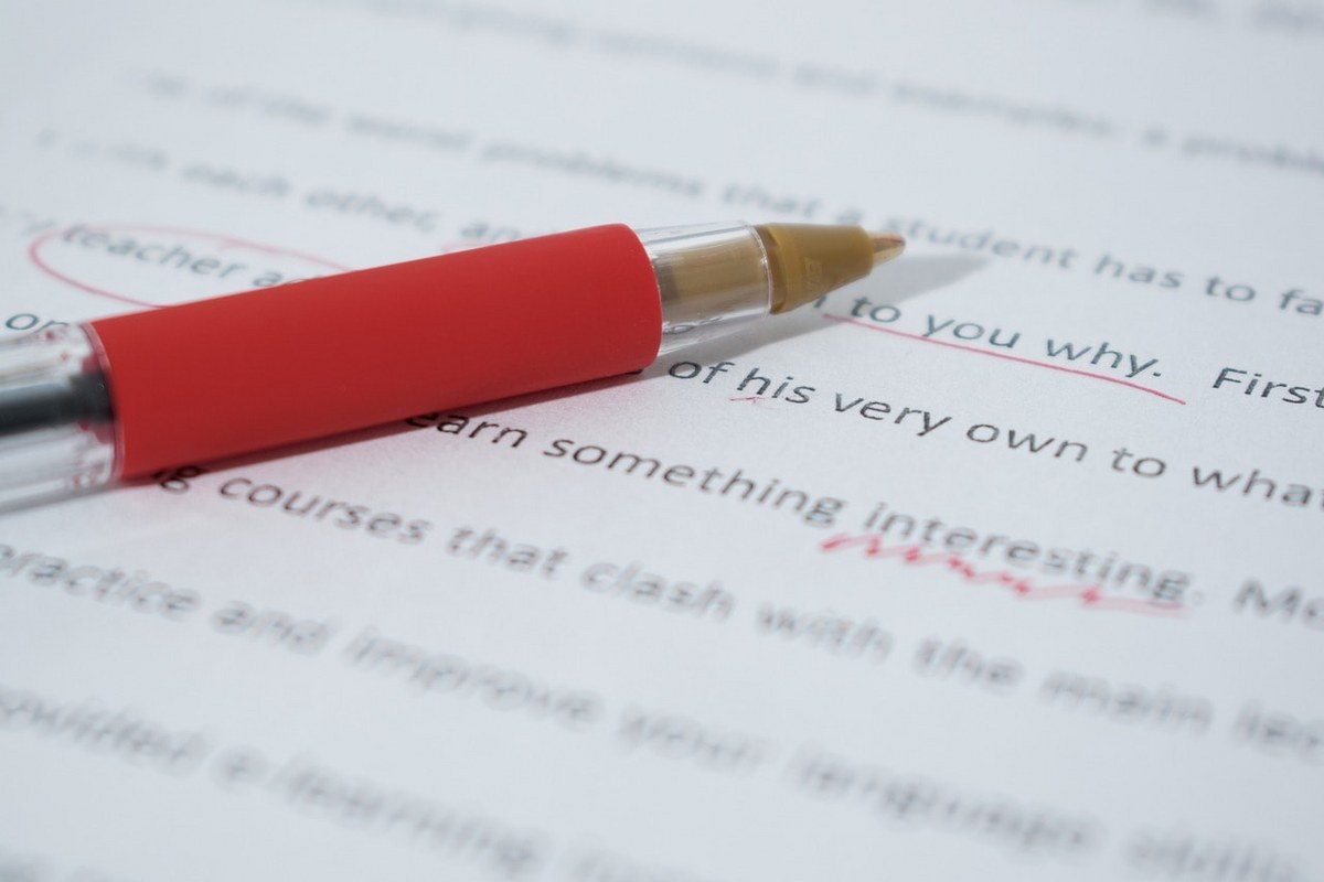 A red pen and a document with outlined mistakes.