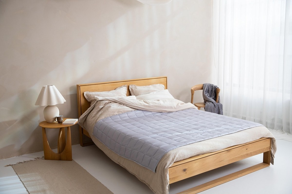 A wooden bed with cotton beddings.