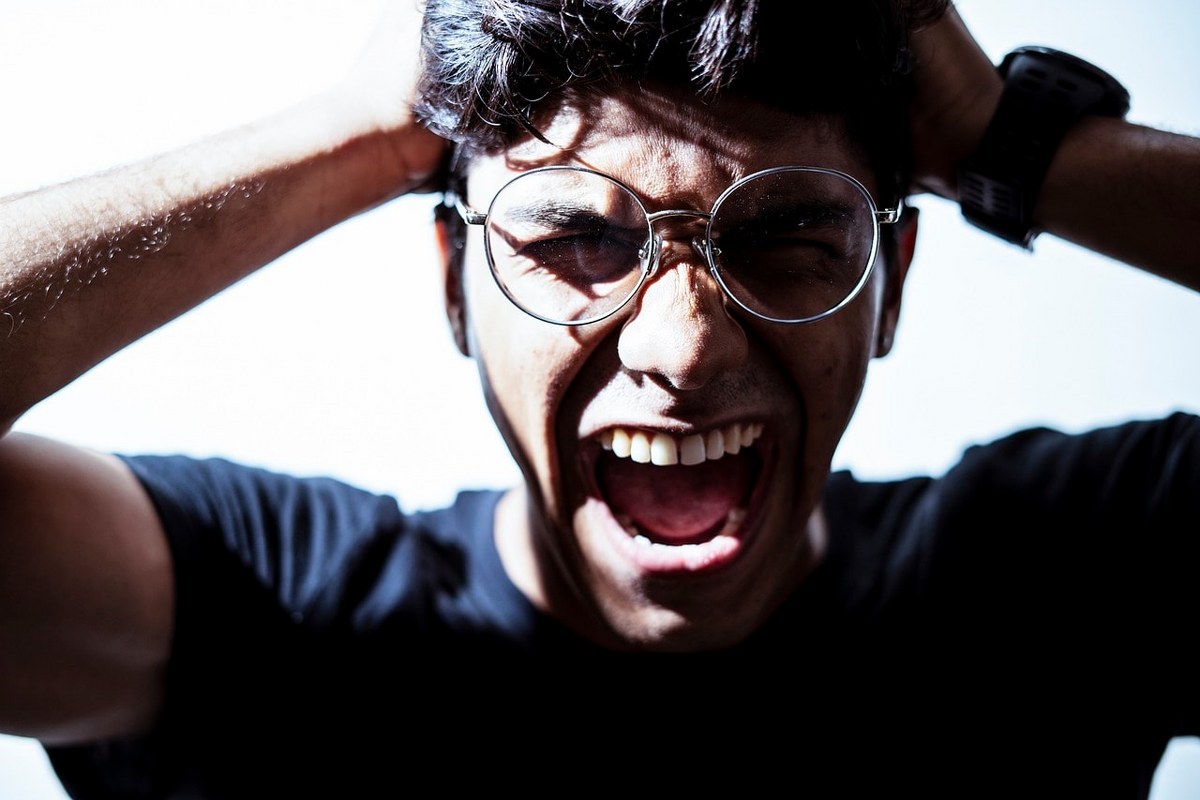 An man expressing emotions that signify anger.