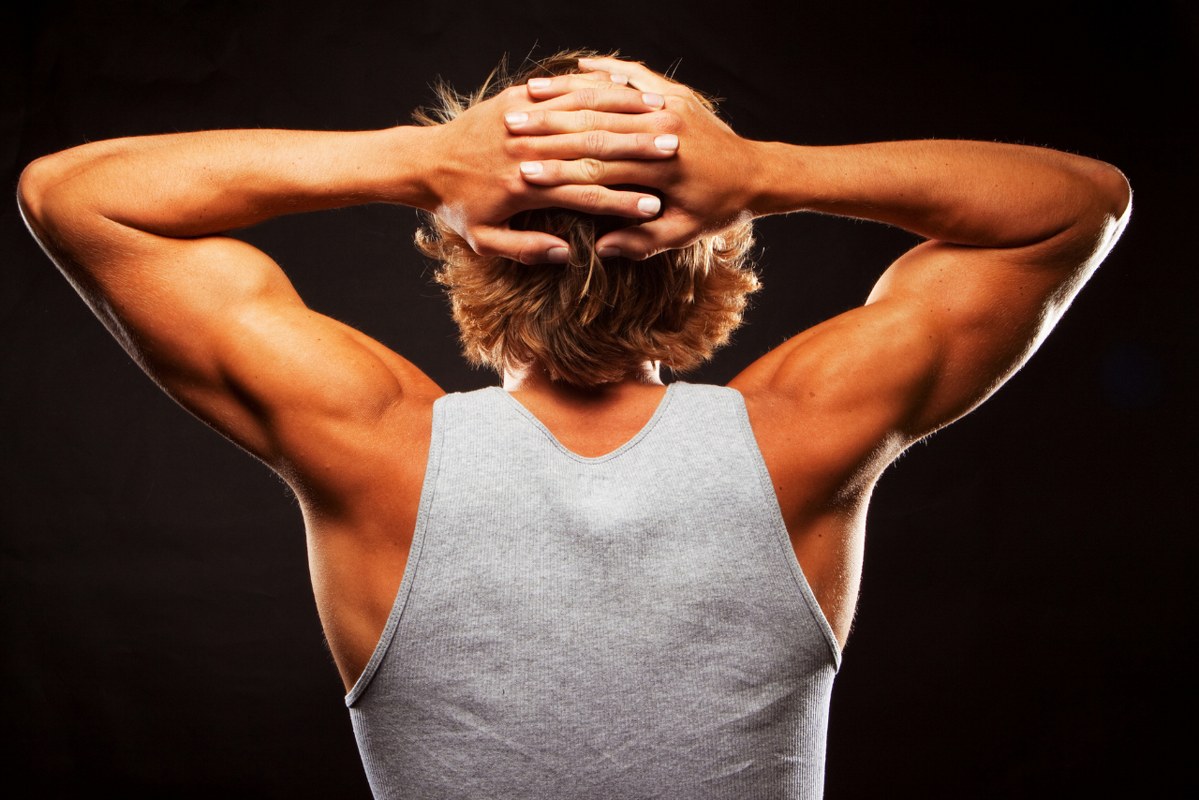 Backview of man flexing triceps, showing fitness.