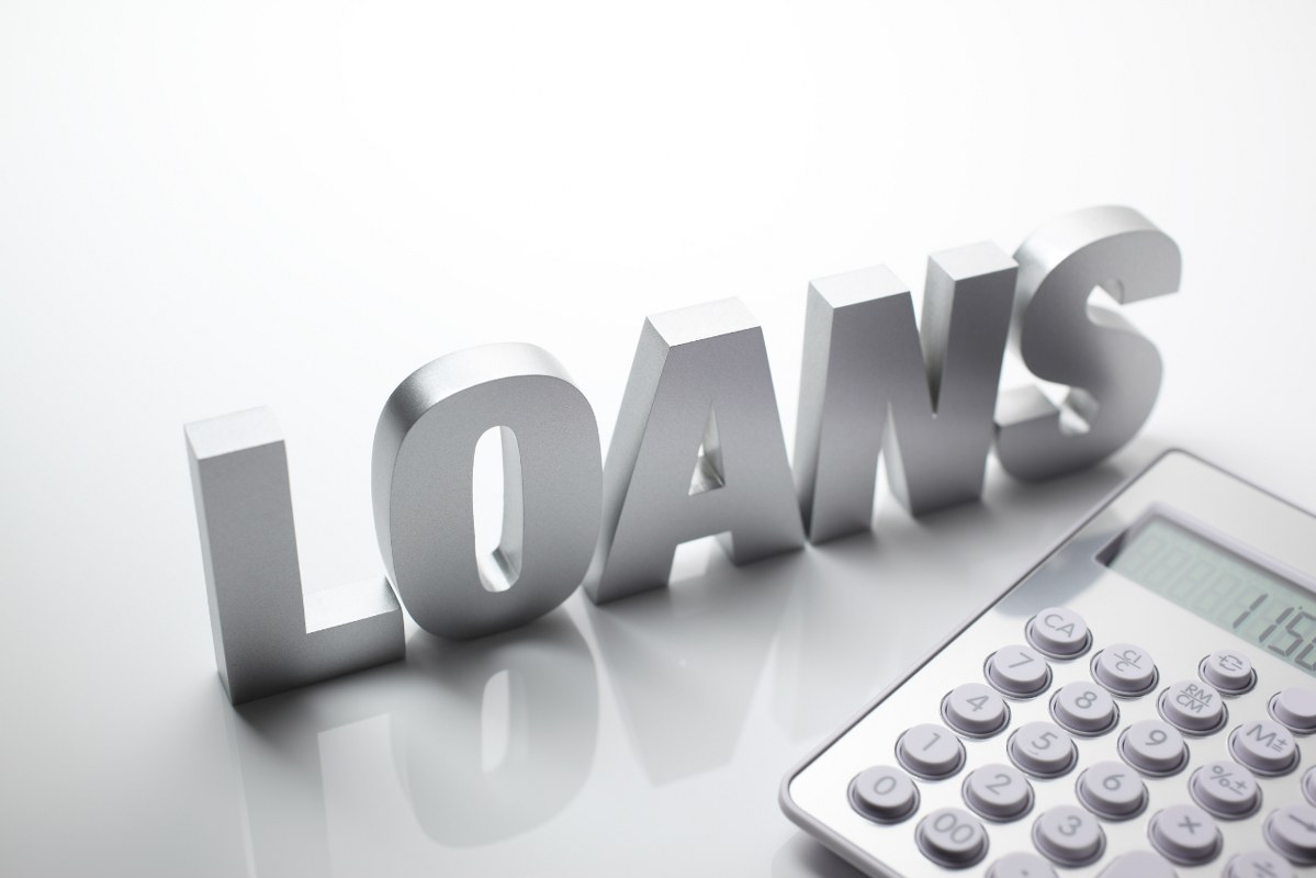 Block letter word LOANS next to a calculator.