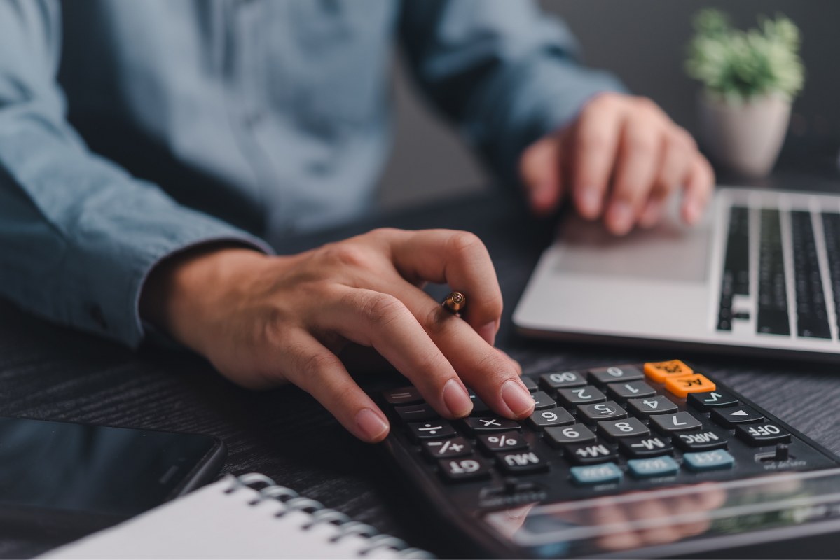 Businessman using calculator to budget.