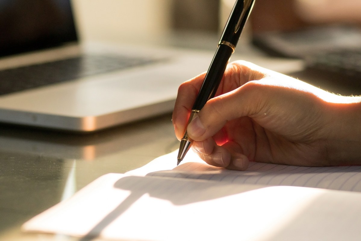 Close up of hand writing in a notebook.