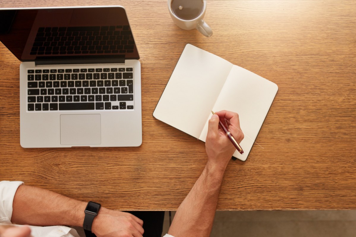 Close up of man doing freelance writing at home.
