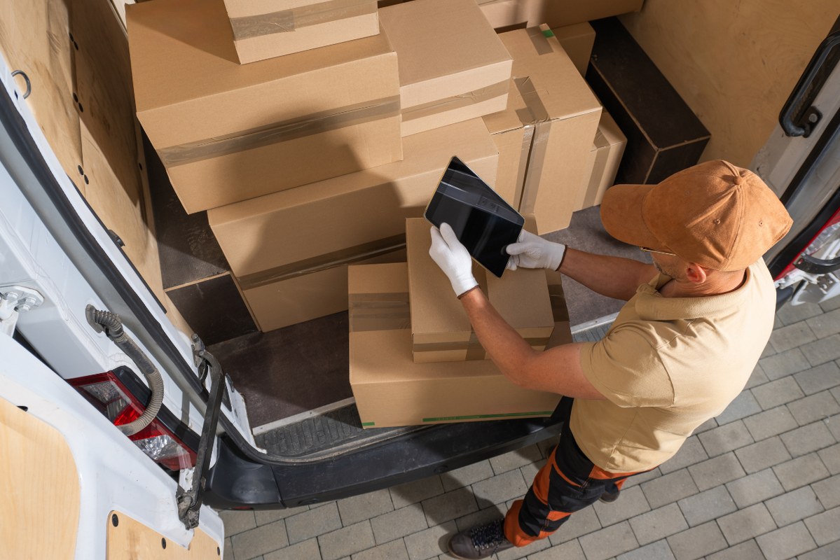 Courier Unloading Shipping Boxes From Truck.