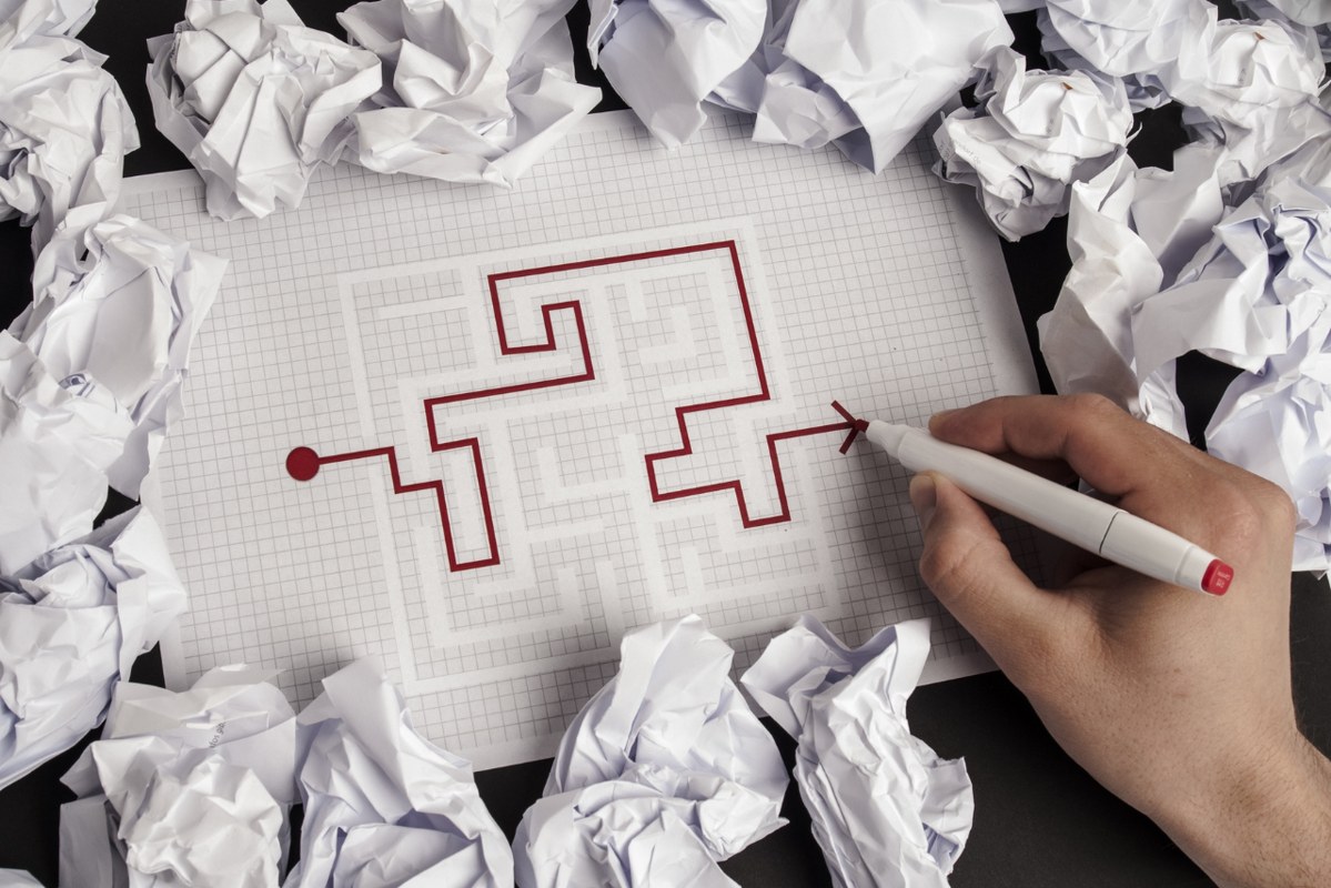 Critical thinking concept: Hand solving puzzle with crippled paper around.
