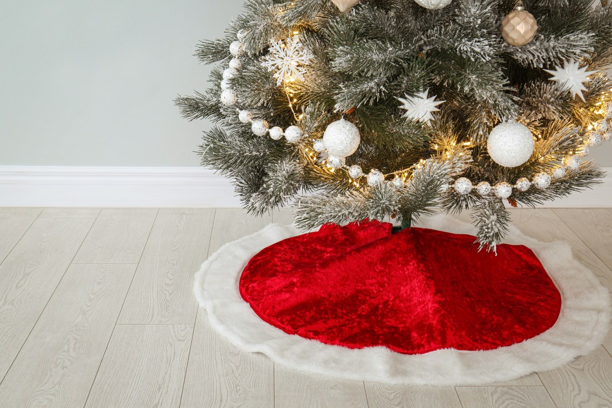 Decorated Christmas Tree with Red Skirt Indoors.