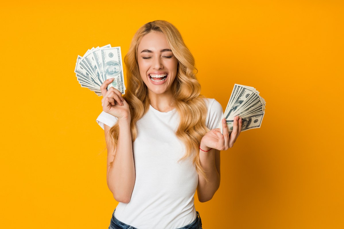 Extremely happy woman holding money.