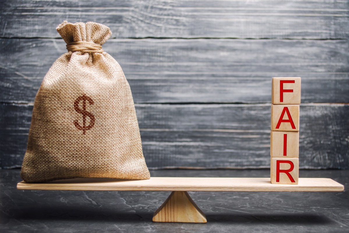 Fair value concept: Money bag and wooden blocks with the word Fair. 