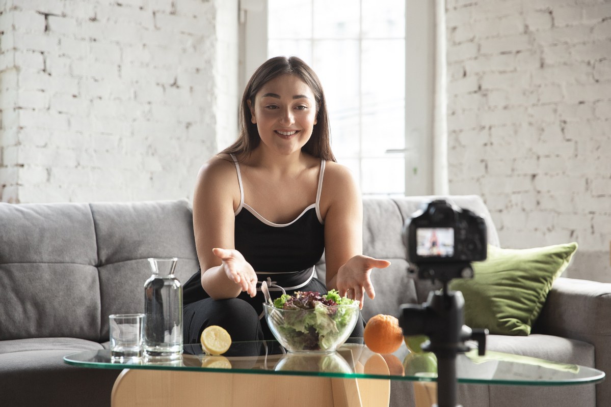 Femal vegan Blogger eats healthy infront of camera.