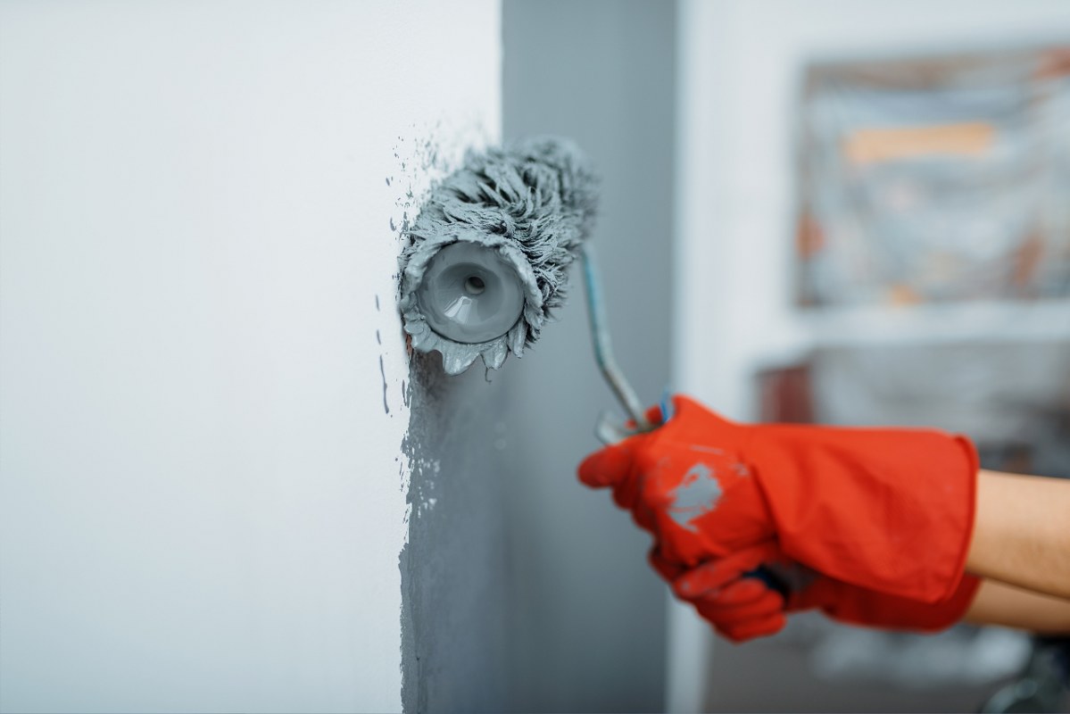 Female House Painter Hand with Paint Roller.