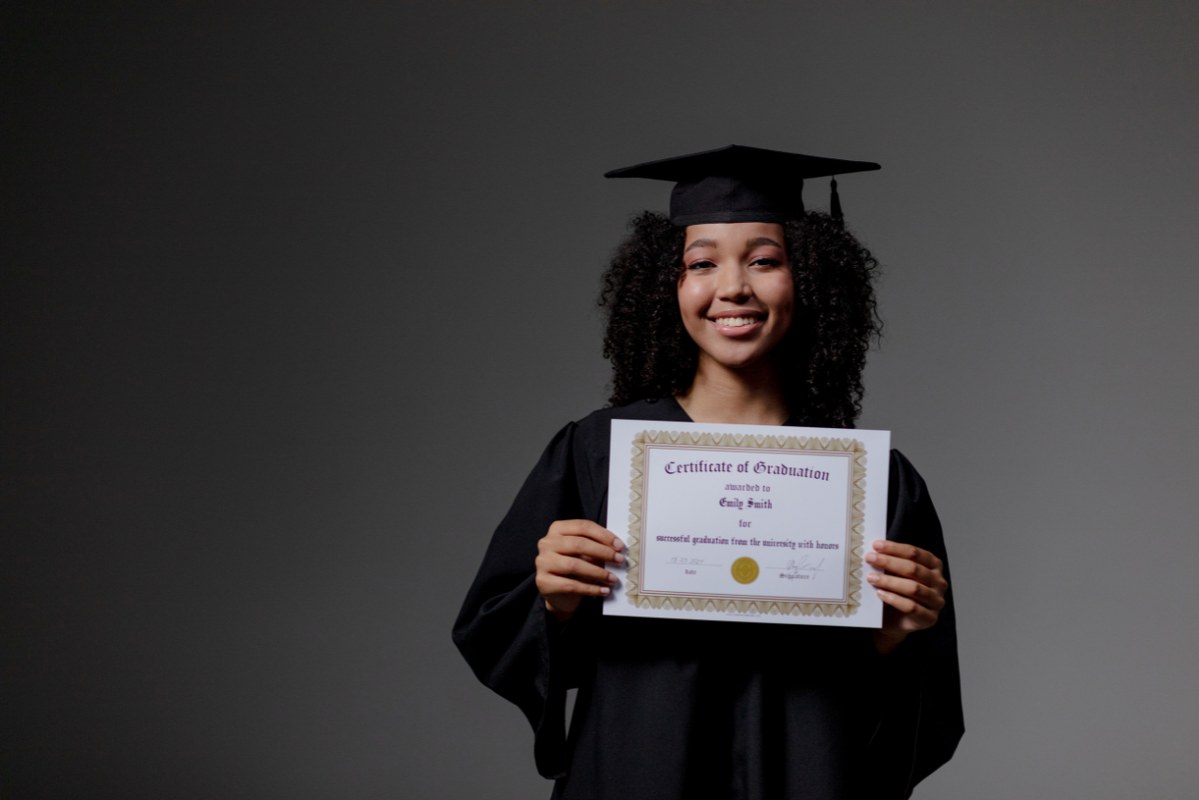Female graduate holding a certificate.