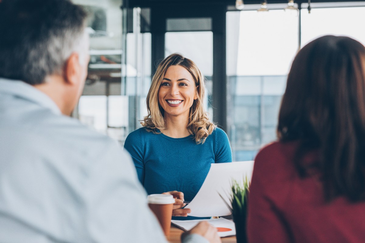 Female insurance agent smiling at couple client.