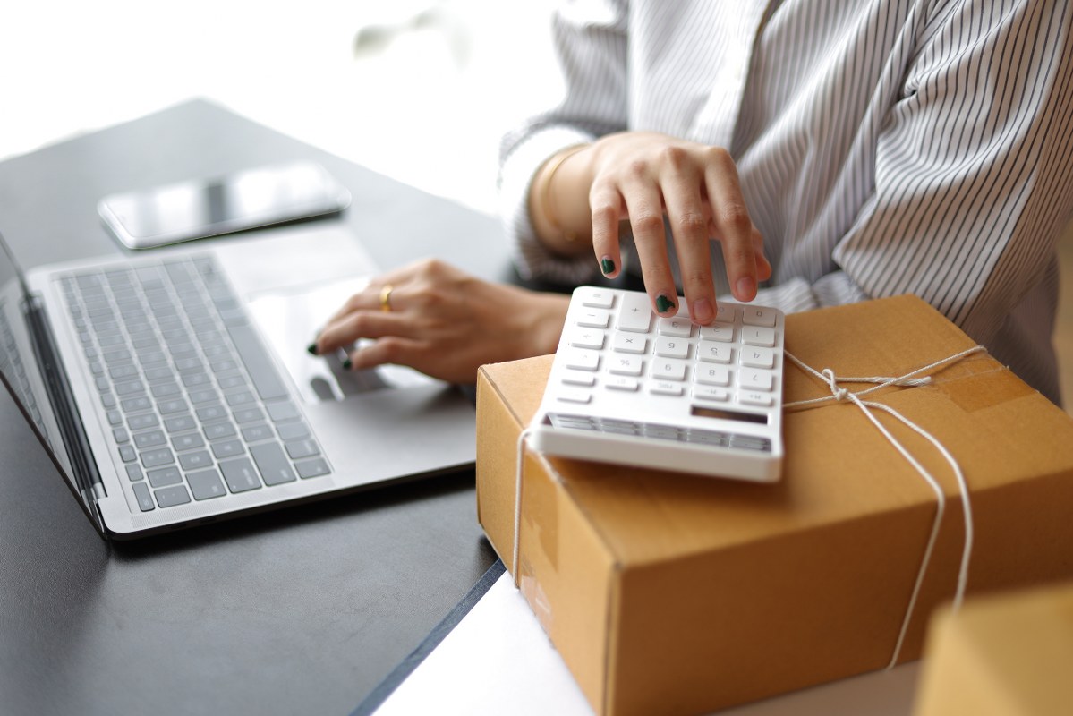 Female operator calculates the cost of goods before shipping.