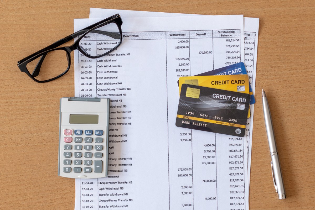 Financial Statement with Credit Card on wooden table.
