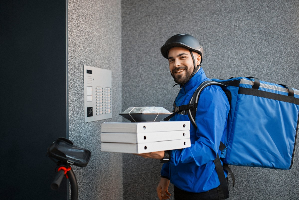 Food delivery man infront of door with his scooter.