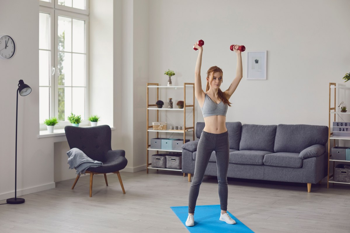 Girl Doing Sports Workout with Dumbbels at Home.