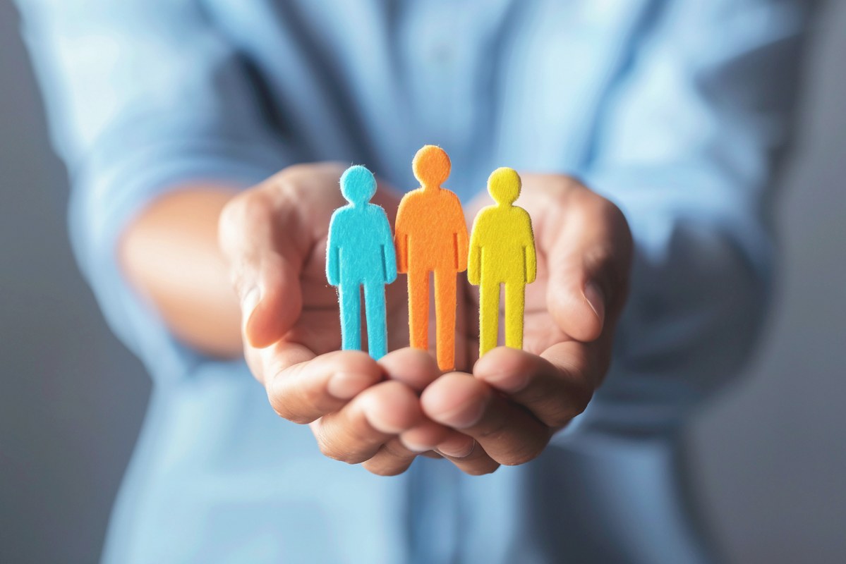 HR Hands holding employee figures on hands.