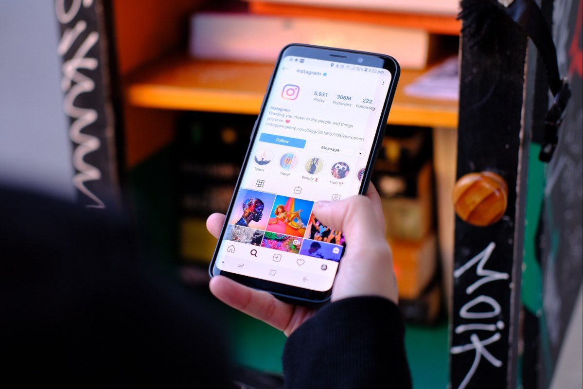 Hand holding phone browsing Instagram_1