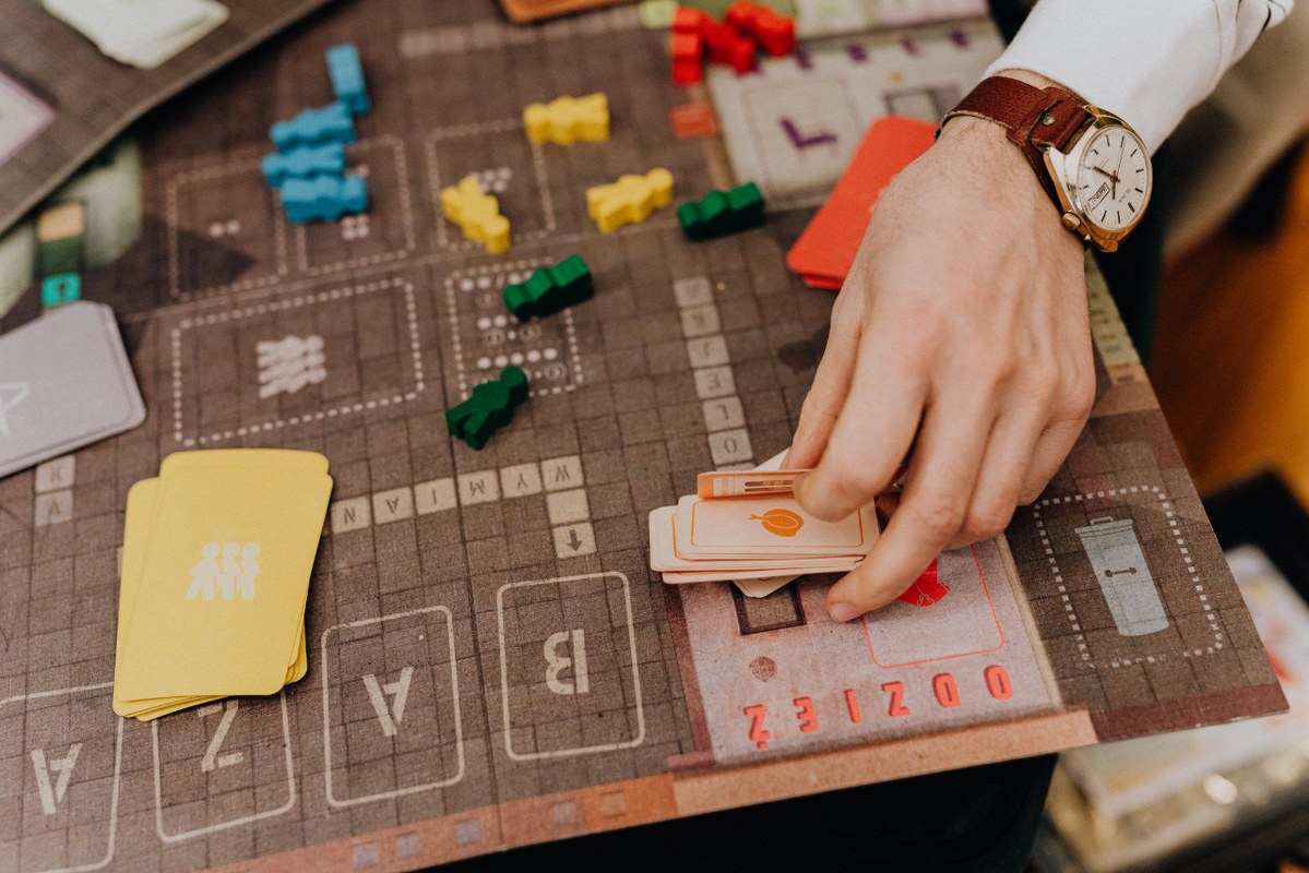 Hand on old game board that is damaged.